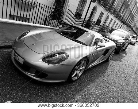 LONDON, UK - CIRCA MARCH 2013: A Porsche Carrera GT parked in the street. The Carrera GT is a mid-engined sportscar produced between 2004 and 2007. Black and white photography.