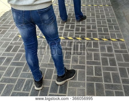 Queue For A Store On Street. Social Distance. Feet Of People Waiting To Safely Enter The Store For F