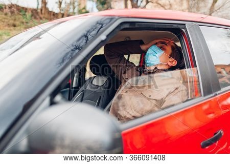 Ill Man Sitting In Car Wearing Protective Mask Feels Fever Sick Has Flu Covid-19 Coronavirus. Infect
