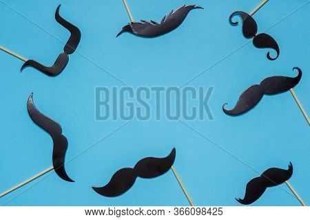 Various Black Photo Booth Props Moustaches Of Different Shape On Blue Background. Greeting Card For 