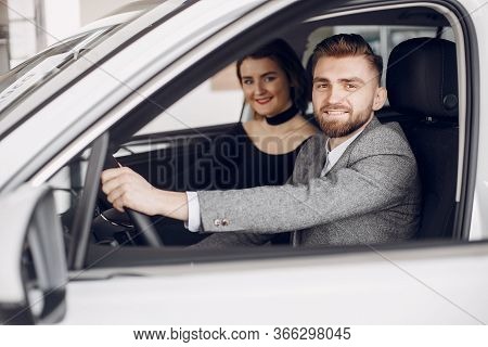 Stylish And Elegant Couple In A Car Salon