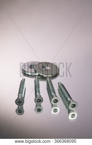 Countersunk Wood Screws On A Gray Background. Mirror Reflection