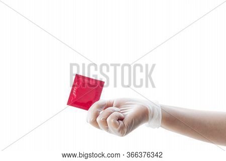 Protection From Stds. A Hand In A Transparent Rubber Glove Holds A Pink Condom. Photo-isolate.