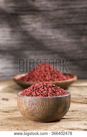 Annatto Seeds In Bowl On Wooden Background