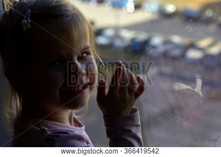 Girl Looks Lonely Through Window By Putting Her Hands On Window Sill