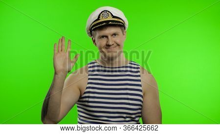 Young Muscular Sailor Man Waving Hand. Seaman Guy Smiling In Sailors Vest. Striped Navy White And Bl