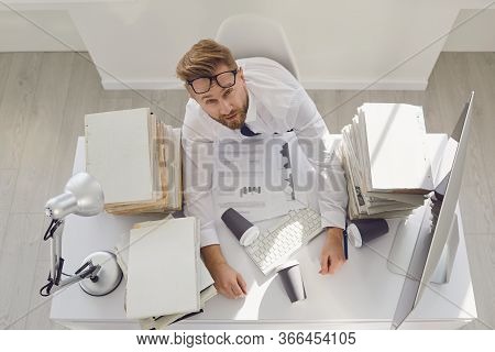 Tired Puzzled Funny Sleepy Businessman At The Workplace At The Table In The Office