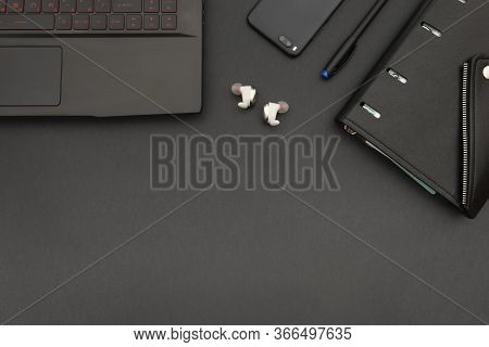 Laptop, Notebook And Phone. Copy Space On Black Table. Flatlay