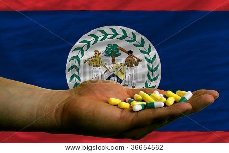 Holder piller i hånden foran Belize nationale Flag