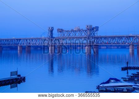 Old Metal Bridge Across The Dneper River In Eastern Europe, Ukraine