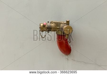 Red Fire Pump In Front Of Concrete Wall. Fire Safety Pump On Cement Floor Of Concrete Building. Delu