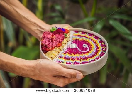 Young Man Having A Mediterranean Breakfast, Eats Healthy Tropical Breakfast, Smoothie Bowl With Trop