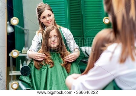 Hairdresser Makes Hairstyle For Beautiful Woman While Looking In The Mirror Reflaction At The Beauty