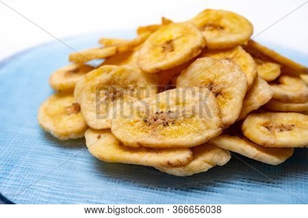Healthy Sweet Snack, Crispy Dehydrated Unsugared Banana Chips On Recycled Glass Plate On White Backg