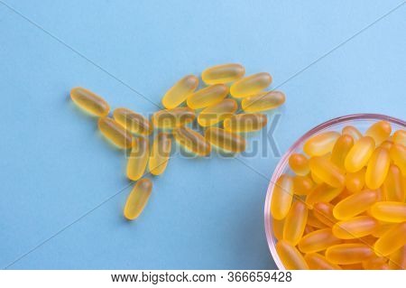 Omega 3 Chewable Jelly Pills Shaped As Fish. A Loty Of Capsules With Yellow Fish Oil Are Lying On Bl