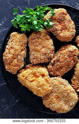 Close-up Of Japanese Pork Cutlets, Hirekatsu On A Black Plate On A Concrete Table, Horizontal View F