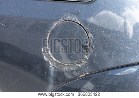 A Close Up View Of A Petrol Cap On The Side Of A Black Car That Has Rusted And Been Repaired With Bl