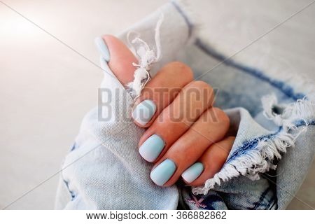 Female Hands With A Beautiful Manicure On A Jeans Background.