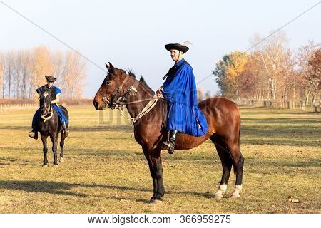 Hortobagy, Hungary, November, 04. 2018: Hungarian Csikos In Traditional Folk Costume Showing Off His