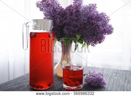 Still Life With A Bouquet Of Lilacs And Compote Of Berries. A Glass Of Compote, A Jug, A Bouquet, A 