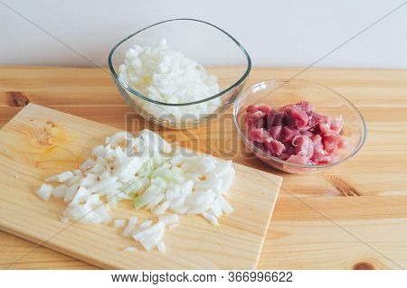 Peeled Onions And Raw Meat On A Wooden Table Background