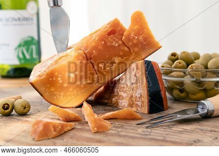 A Piece Of Old Amsterdam Cheese With Olives And Wine.
