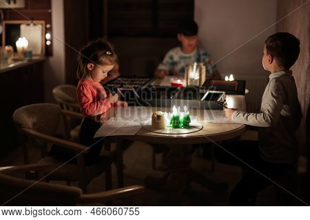 Family Spending Time Together During An Energy Crisis In Europe Causing Blackouts. Kids Drawing In B