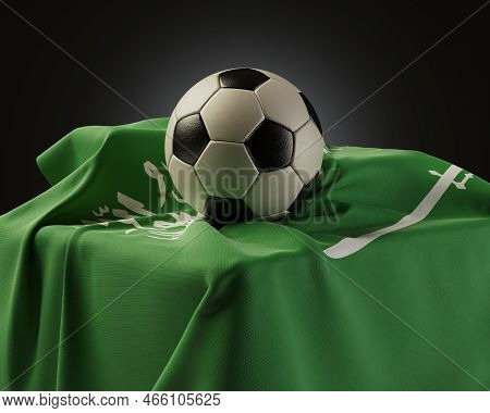 A Regular Soccer Balls Resting On A Saudi Arabia Flag Draped Over A Plinth On An Isolated Studio Bac