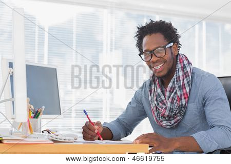 笑みを浮かべてデザイナー モダンなオフィスで机の上に赤い鉛筆で描画