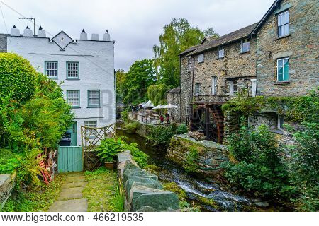 Ambleside, Uk - September 25, 2022: View Of Old Houses And A Watermill, With Locals And Visitors, In