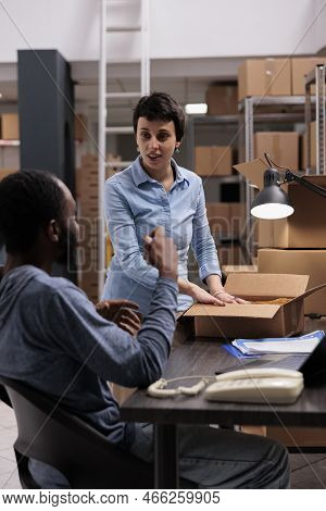 Supervisor And Manager Discussing Transportation Logistics While Preparing Packages, Putting Custome