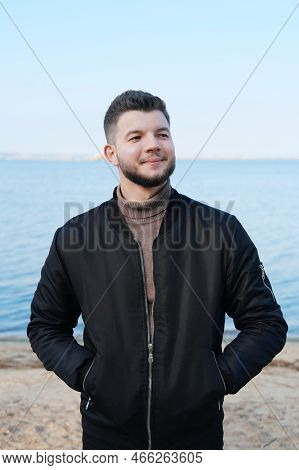 A Young Man Stands On The Beach With A Lake In The Background. Stress-free Concept. Slow Living. Enj