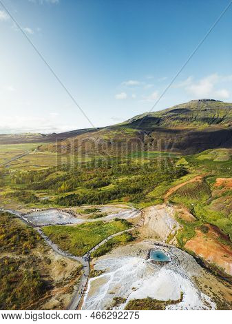 Tourist Exploring Area Of Great Geyser In Iceland - Vertical Aerial Photo