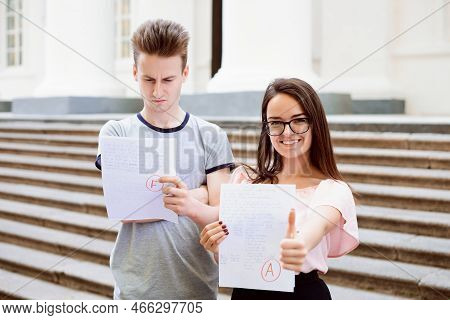 Two Students With Test Results. Happy Female Student Have Received Excellent A Grade, But Her Male F