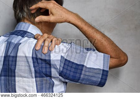 Pain In The Shoulder Joint Of Southeast Asian Elder Man. Concept Of Frozen Shoulder.