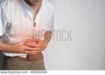 Asian Young Man Suffering From Upper Abdominal Pain. It Can Be Caused By Stomach Ache, Enteritis, Co