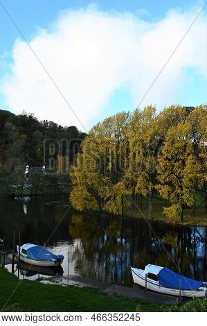 A View Of A Calm Stretch Of The River Dochart With The Autumn Coloured Trees Reflected In The Water 