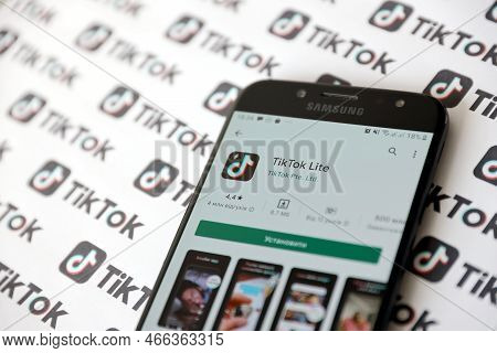Ternopil, Ukraine - May 2, 2022: Tik Tok Smartphone App On Screen And Many Tiktok Logo Printed On Pa
