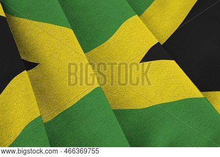 Jamaica Flag With Big Folds Waving Close Up Under The Studio Light Indoors. The Official Symbols And