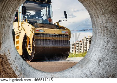 Vibratory Road Roller Lays Asphalt On A New Road Under Construction. Close-up Of The Work Of Road Co