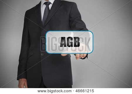 นักธุรกิจที่แตะป้ายขาวกับ agb คำที่เขียนไว้บนพื้นหลังสีเทา