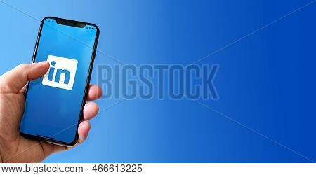 Paris - France - March 15, 2022 : Hand Holding Iphone Smartphone With Linkedin Logo. Horizontal Bann