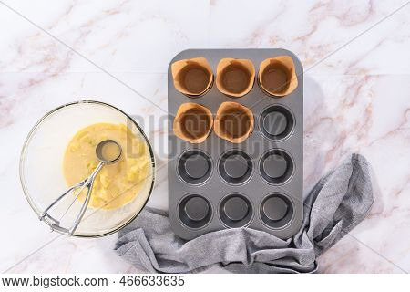 Flat Lay. Scooping Dough Into The Cupcake Pan Lined With Parchment Muffin Liners To Bake Sharlotka M