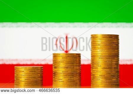 Upgoing Graph Made Of Coins Stacked In Front Of Iran Flag. Concept Of Financial Development Of Iran