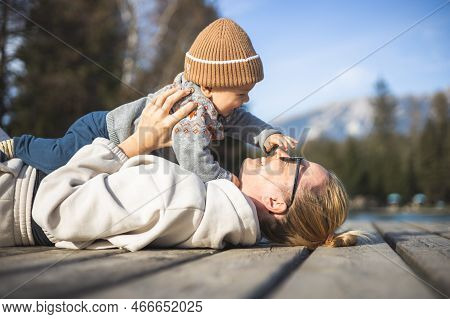 Happy Family. Young Mother Playing With Her Baby Boy Infant Oudoors On Sunny Autumn Day. Portrait Of