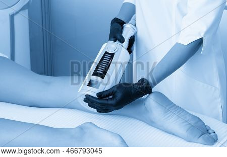 Cosmetologist In Rubber Gloves Doing Endospheres Therapy On Female Legs