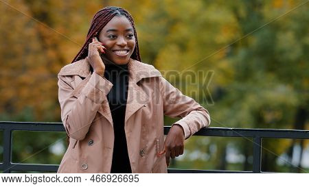 Young Confident Woman Standing Outdoors Talking On Telephone Answering Business Call Remotely Orders