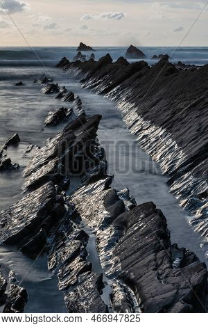 Stunning Sunset Landscape Image Of Welcome Mouth Beach In Devon England With Beautiful Rock Formatio