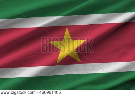 Suriname Flag With Big Folds Waving Close Up Under The Studio Light Indoors. The Official Symbols An