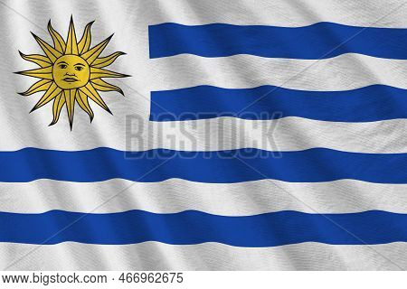 Uruguay Flag With Big Folds Waving Close Up Under The Studio Light Indoors. The Official Symbols And